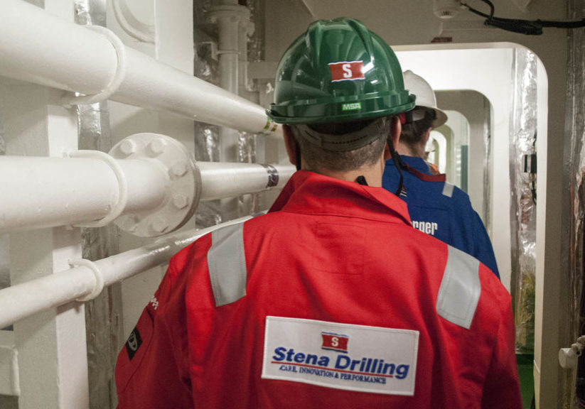 Stena Drilling personnels walking with hard hats in the ship coridor