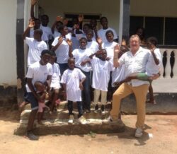 Kids and a man standing outside Ghana Orphanage