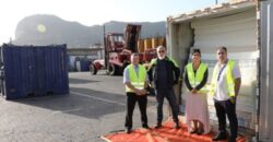 People with light green vest standing outside container vans